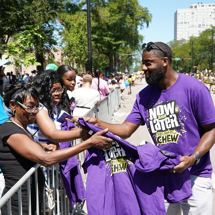 A Ferrara employee handing out Now and Later tshirts during a parade